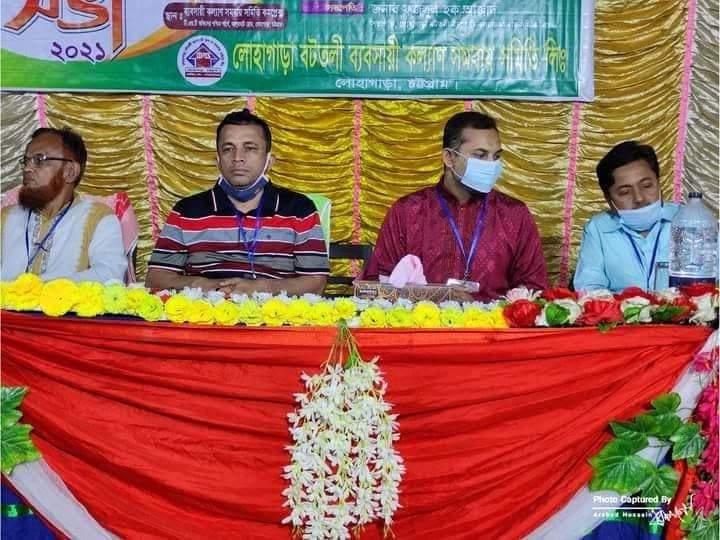 মঞ্চে অতিথিরা বসে আছেন; পেছনে সমিতির নাম লেখা ব্যানার, সামনে ফুলে সাজানো টেবিল