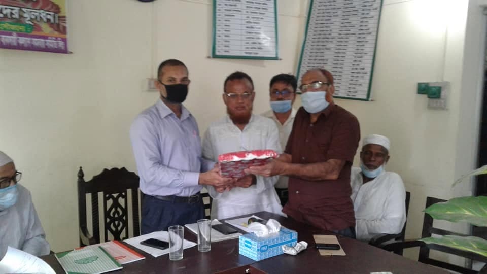 অফিসের টেবিলের পাশে একজনের হাতে উপহার তুলে দেওয়া হচ্ছে