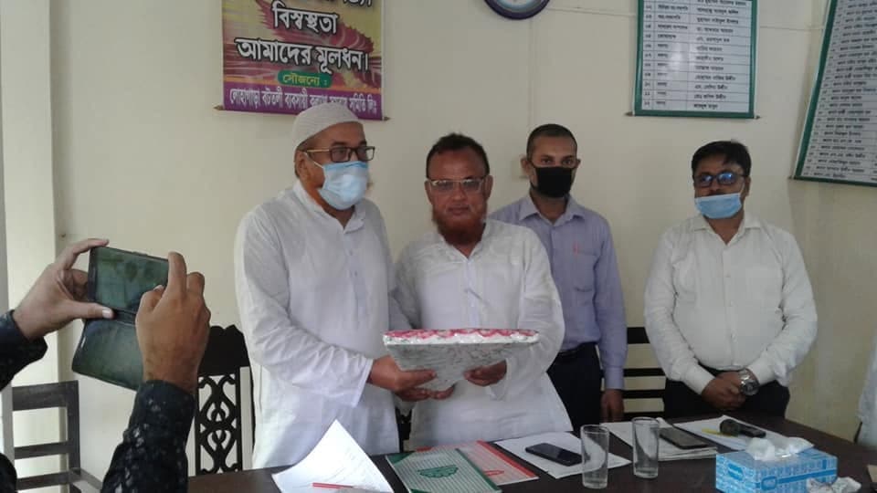 অফিসে উপহার দেওয়া হচ্ছে; পেছনের পোস্টারে লেখা "বিশ্বস্ততা আমাদের মূলধন"