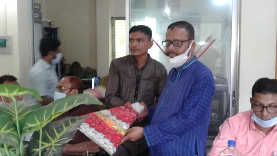 অফিসে একজনকে ফুলের তোড়া দিয়ে শুভেচ্ছা জানানো হচ্ছে