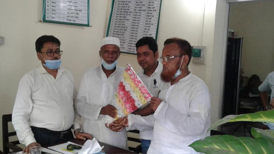 অফিসে চারজন; একজনকে ফুলের তোড়া দেওয়া হচ্ছে